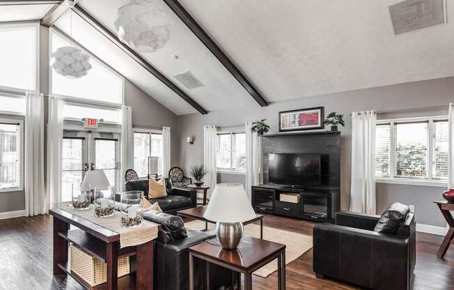 A living room with a black couch, a coffee table, and a fireplace.