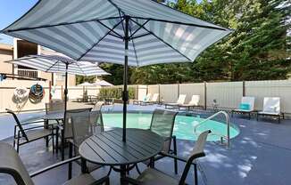 Unique Swimming Pool with Table, Chairs, and Umbrella for Relaxing in the Shade at Park 210 Apartment Homes, Washington