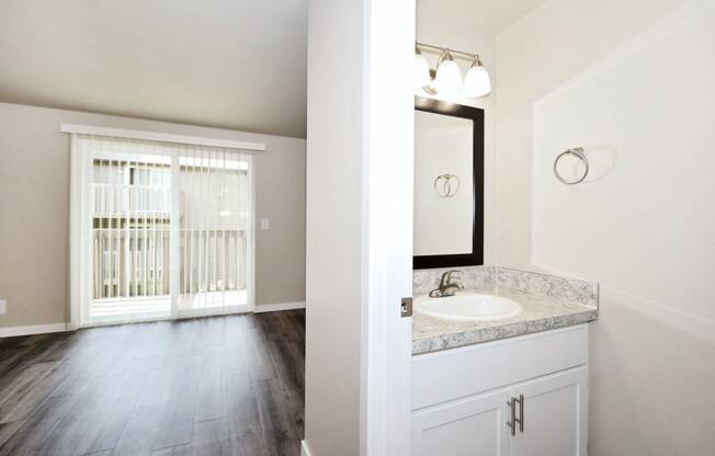 an empty bathroom with a window and a sink and mirror