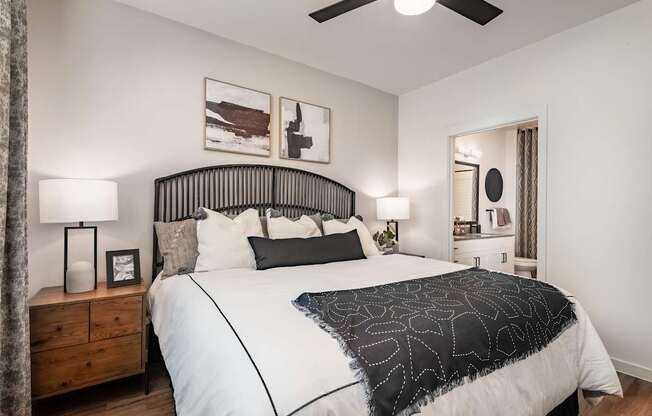 A bedroom with a large bed and a ceiling fan.