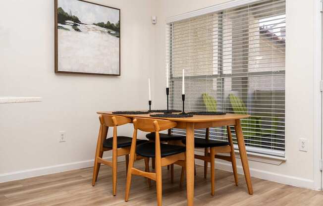 A dining room with a wooden table and chairs.