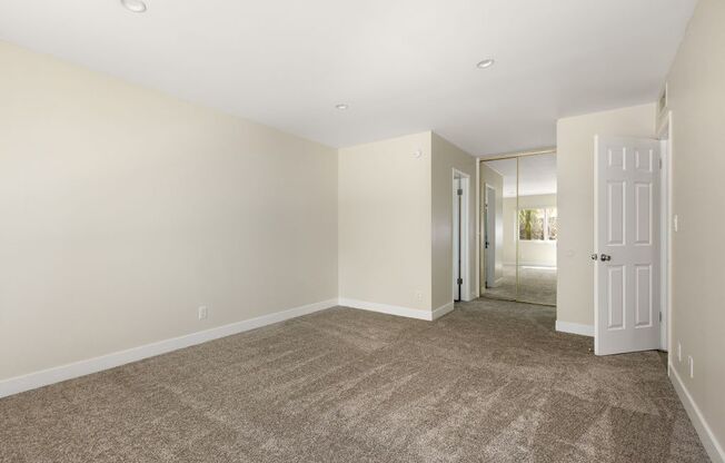 a room with carpet and a door to a hallway