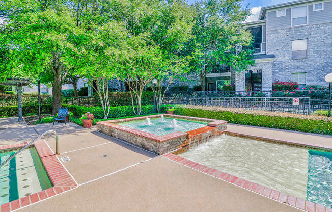 a fenced in swimming pool with trees and a building in the background