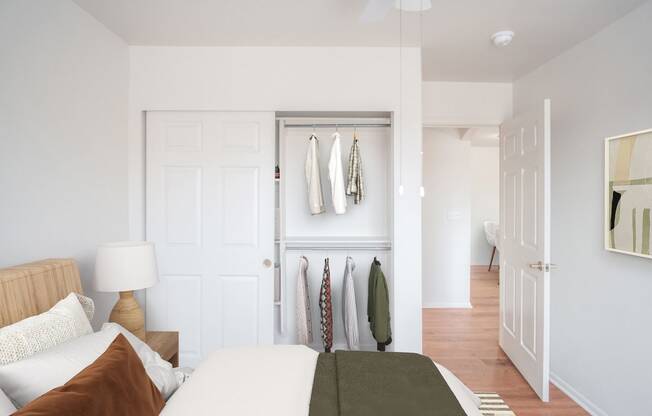 a bedroom with a bed and a closet with clothes