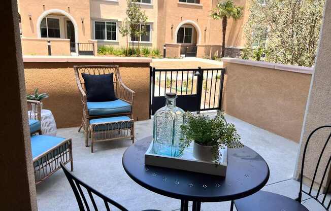 a balcony with a table and chairs and a vase on it