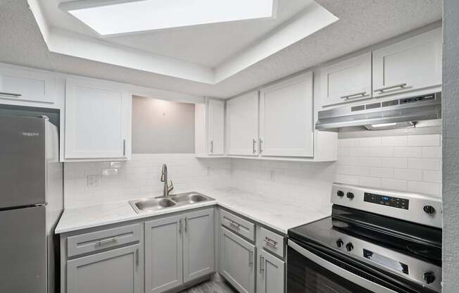A kitchen with white cabinets and a black stove top oven.