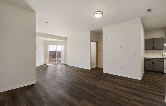 Large living area with wood flooring, bright white walls and sunny glass doors to balcony.at Shoreline Village, Richland Washington