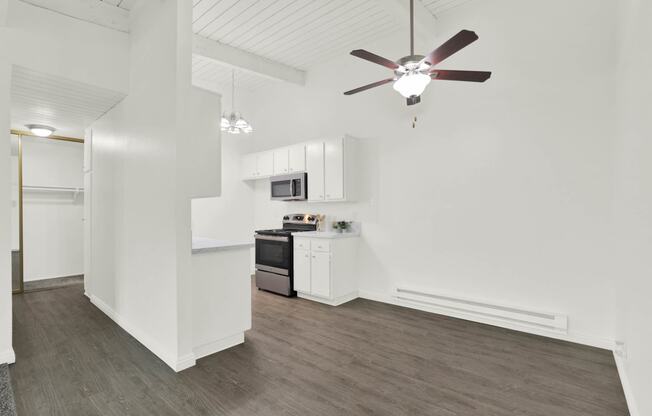 a living room with a ceiling fan and a kitchen at Willow Tree Apartments, Torrance