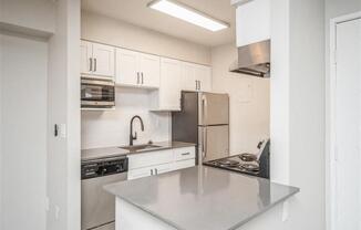 Kitchen with white cabinets and stainless steel counter tops at Avery Park in Englewood, CO