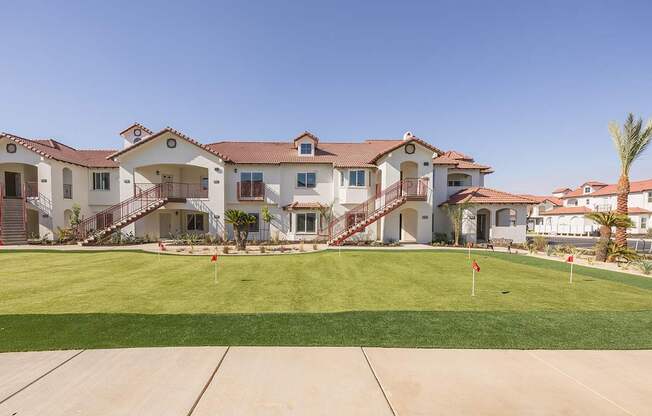 A large house with a red roof and a green lawn in front.
