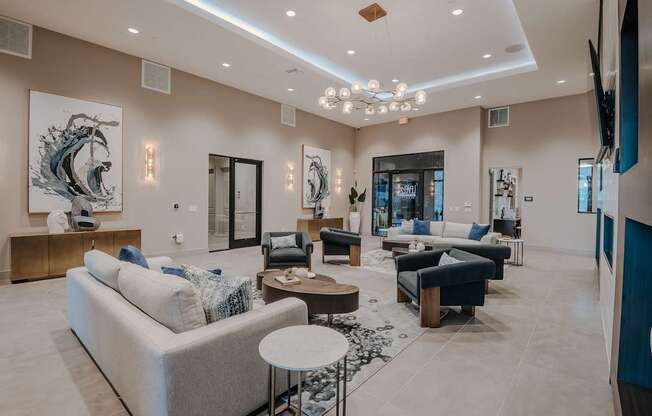 A spacious clubhouse with a variety of seating options and artwork on the walls.