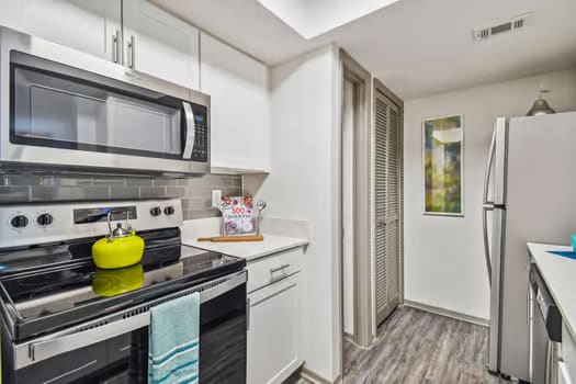 a kitchen with white cabinetry and black appliances