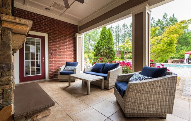 a covered patio with wicker furniture and a fireplace