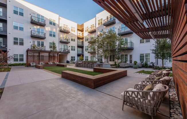 Apartments for Rent in Downtown Dallas, TX - 4600 Ross - Modern Courtyard with Comfortable Seating Options, a Grilling Station, and Beautiful Landscaping