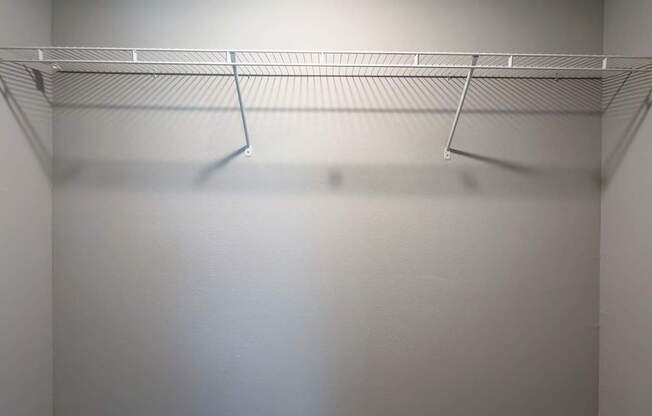 A white closet with a shelf and a light on at Mandarin Bay Apartments