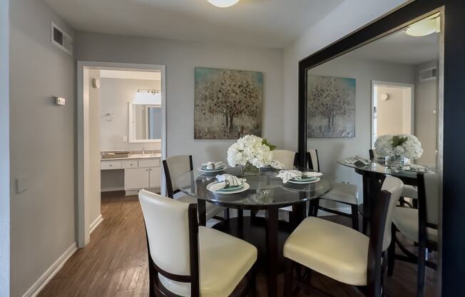 a dining room with a table and chairs and a mirror