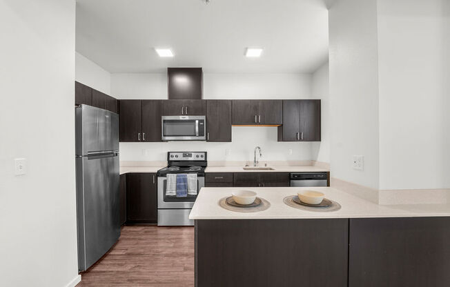 a kitchen with dark cabinets and white countertops