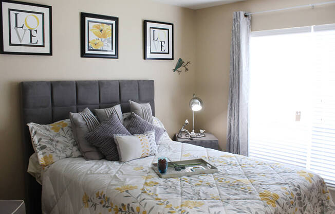 a bedroom with a large bed with a white and yellow comforter