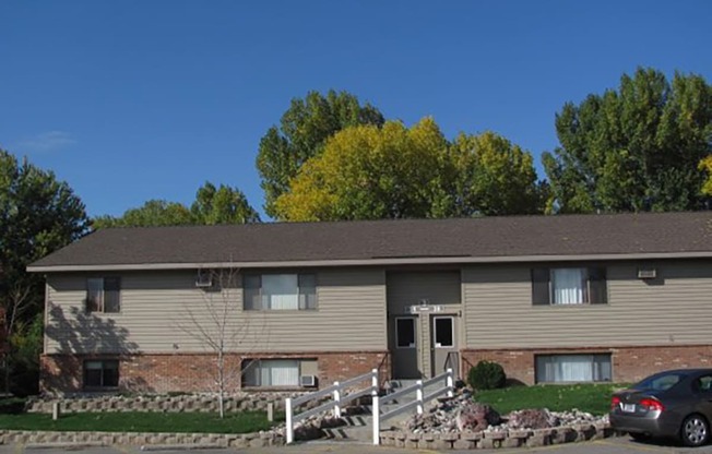 a tan house with a car parked in front of it at Rock Creek, Billings