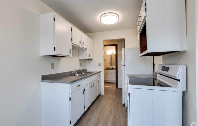 A kitchen with white cabinets and appliances.