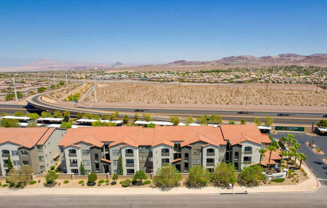 A large apartment complex with a parking lot in front.