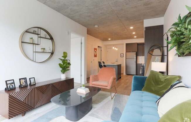 A living room with a blue couch and a glass table.