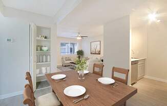 A dining room with a wooden table set for two.