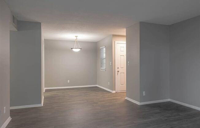A room with a wooden floor and a white door.