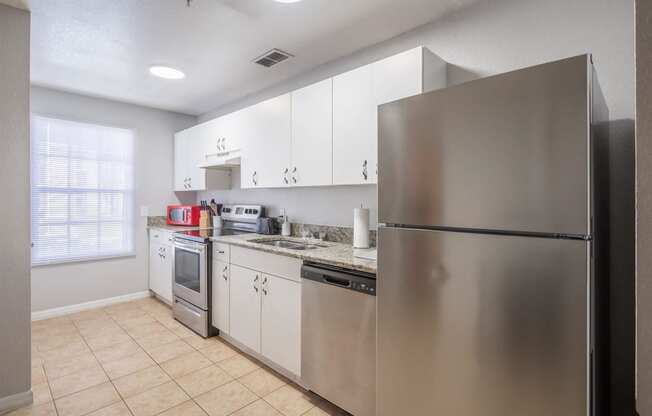 a kitchen with stainless steel appliances and white cabinets