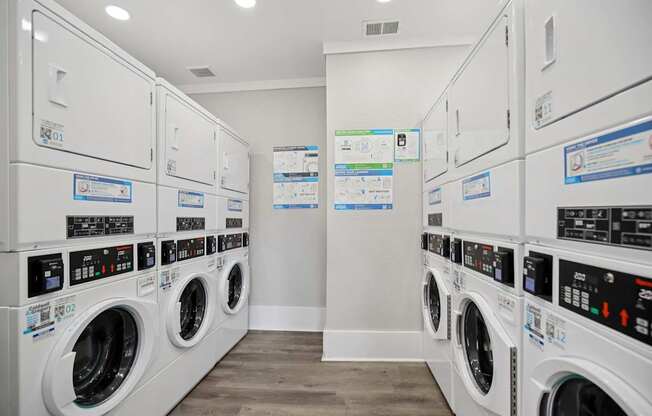 A row of white front load washing machines in a laundromat.
