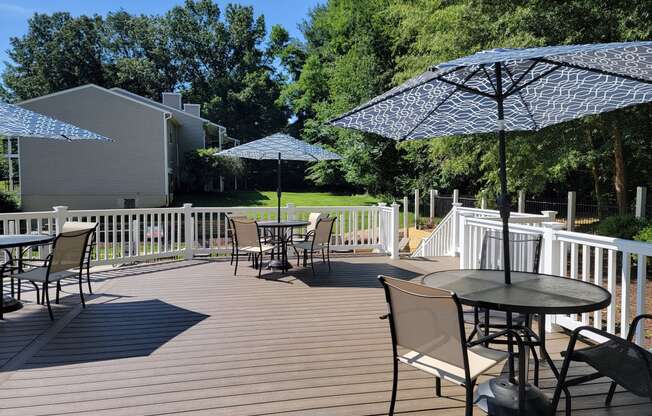 a patio with tables and umbrellas on a deck