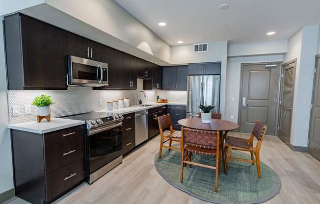 Eat-In Kitchen With Dining Room Table, Black Cabinets, White Countertops, And Stainless-Steel Appliances. at Bayswater Apartments, Burlingame, 94010