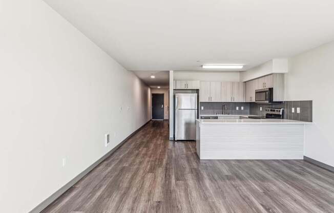 A kitchen with a refrigerator, microwave, and oven.