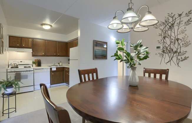 Apartments in Harrisburg | Twin Lakes Apartments | a dining area with a wooden table and chairs and a kitchen in the background