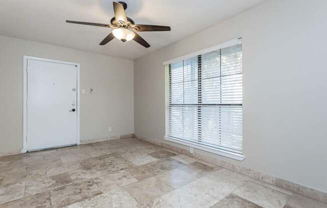 A room with a ceiling fan and a door.