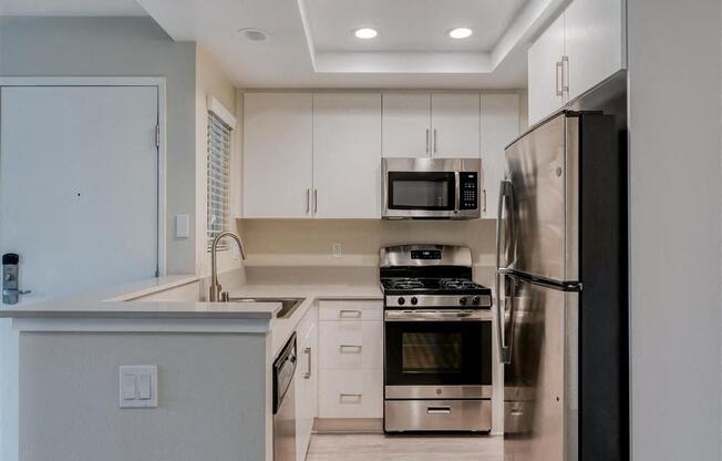 a kitchen with white cabinets and stainless steel appliances  at Laguna Gardens Apts., Laguna Niguel, CA, 92677