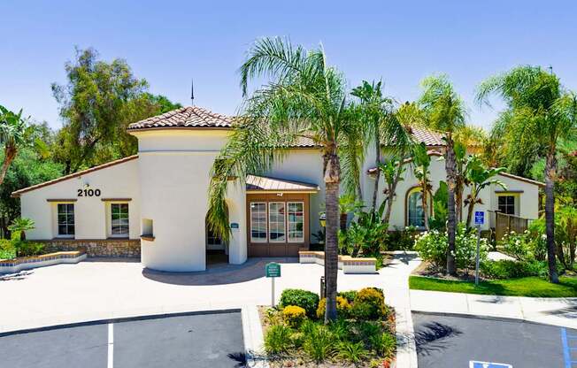 A building with the number 2100 on it is surrounded by palm trees.