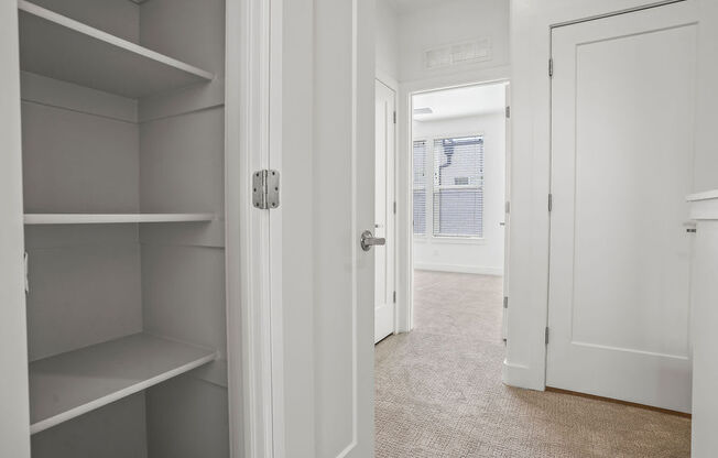a walk in closet with shelves and a door to a bedroom  at Aero Luxury Townhomes in Layton, Utah