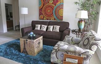 a living room with a brown couch and a rug