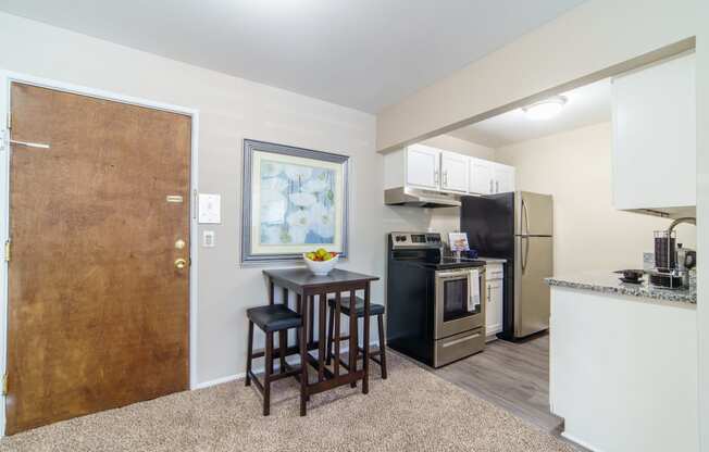 Eating area with beige carpeting and updated kitchen.