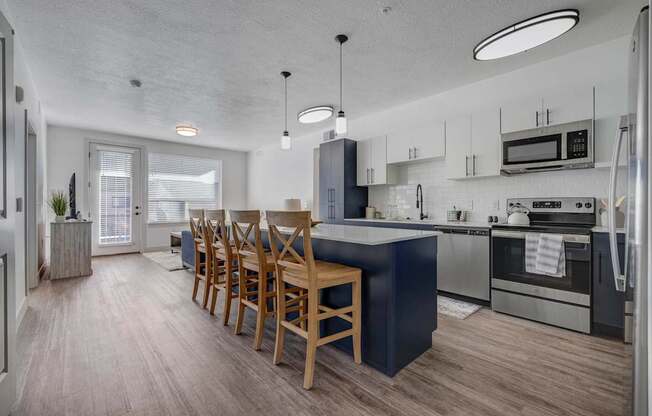 A modern kitchen with a dining table and chairs.