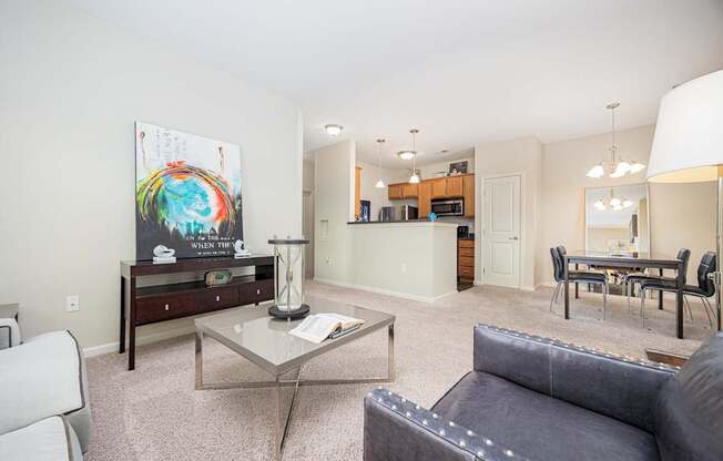 A living room with a grey couch and a glass coffee table.