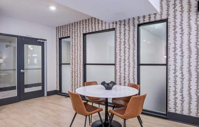 A room with a round table and chairs.