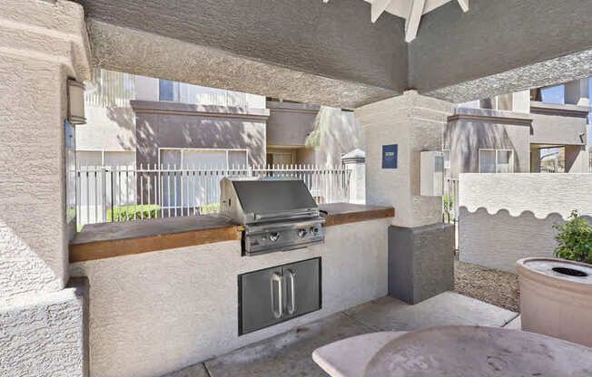 A patio with a grill and a table.