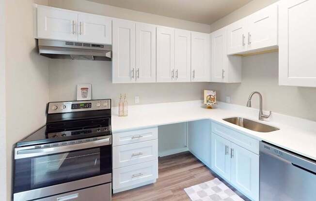 Renovated kitchen at Peak 88 Apartments Renton WA with bright white cabinets, stainless appliances, and ample counter space.