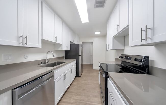 a kitchen with white cabinets and stainless steel appliances