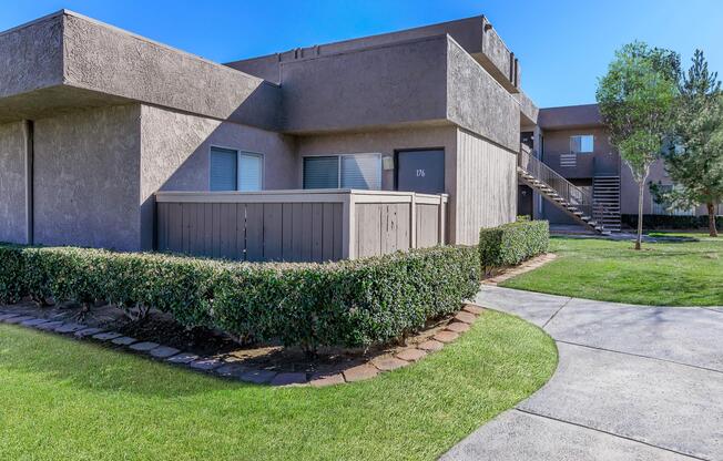 a close up of a stone building with grass in front of a house