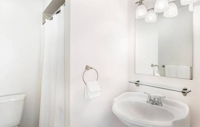 a bathroom with a white sink and a white shower curtain