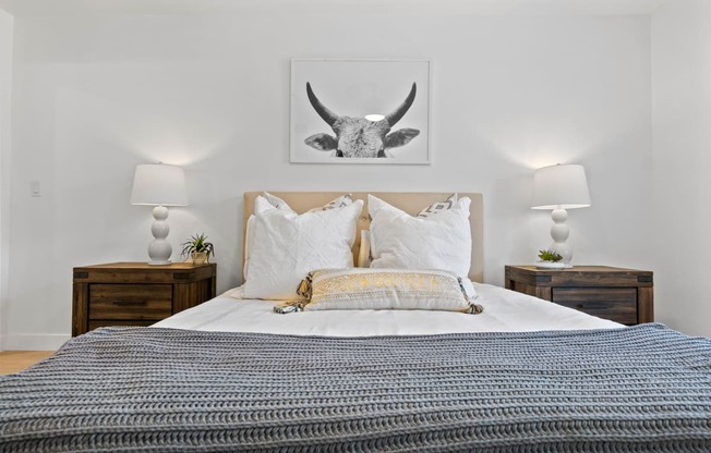 a bedroom with a bed and a picture of a bull