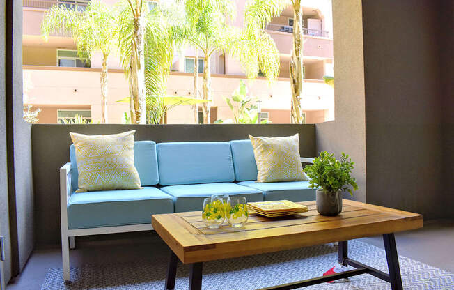 A blue couch with a wooden table in front of it.